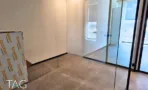 חדר בACRO BUSINESS CAMPUS עם קירות טיח בהירים ומחיצת זכוכית שחורה - תג נכסים