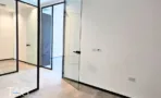 חלל משרדי בACRO BUSINESS CAMPUS עם מחיצות זכוכית שחורות ורצפת אריחים - תג נכסים