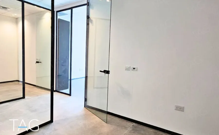 חלל משרדי בACRO BUSINESS CAMPUS עם מחיצות זכוכית שחורות ורצפת אריחים - תג נכסים
