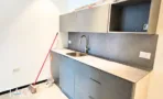 מטבחון בACRO BUSINESS CAMPUS עם ארונות אפורים כהים וחיפוי קיר תואם - תג נכסים