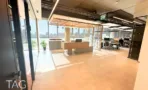 אופן ספייס בACRO BUSINESS CAMPUS עם עמדות עבודה, תקרת סנפירי עץ וחלונות רחבים - תג נכסים
