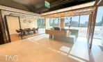 אזור קבלה בACRO BUSINESS CAMPUS עם דלפק עץ, תקרת סנפירים וחדר ישיבות מזוגג - תג נכסים