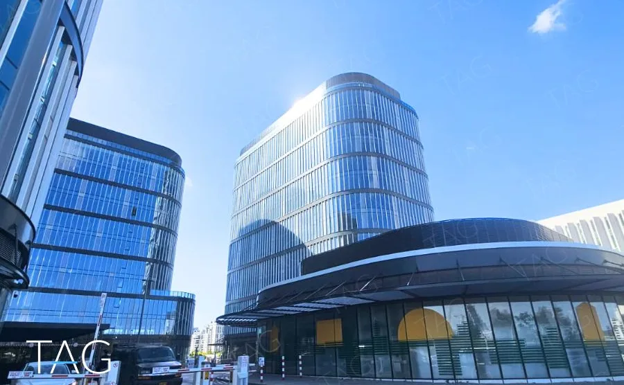 מגדלי ACRO BUSINESS CAMPUS מלמטה עם גגון מסחרי מעוגל כהה בחזית - תג נכסים
