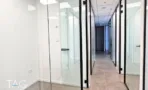 משרד להשכרה 135 מ״ר במגדל WE, מסדרון עם חדרים במחיצות זכוכית ומסגרות שחורות