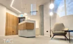 אזור קבלה בACRO BUSINESS CAMPUS עם דלפק בחיפוי עץ, עמוד בטון וגופי תאורה כדוריים - תג נכסים