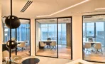 חלל משרדי בACRO BUSINESS CAMPUS עם חדרי זכוכית, תאורה ליניארית ופרקט עץ - תג נכסים