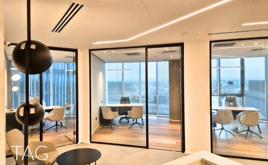 חלל משרדי בACRO BUSINESS CAMPUS עם חדרי זכוכית, תאורה ליניארית ופרקט עץ - תג נכסים