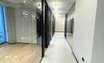 מסדרון משרדים בACRO BUSINESS CAMPUS עם קיר זכוכית לכל האורך ותאורה שקועה - תג נכסים