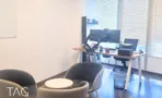 פינת ישיבה עם כורסאות מול עמדת עבודה וחלון עם תריסים במשרד להשכרה 220 מ