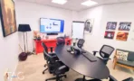 חדר ישיבות במשרד במגדל רוטשילד 3 עם שולחן אובלי כהה, מסך על הקיר ולוח מחיק