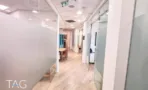 מסדרון עם מחיצות זכוכית חלבית ודלתות הזזה במשרד במגדל רוטשילד 3