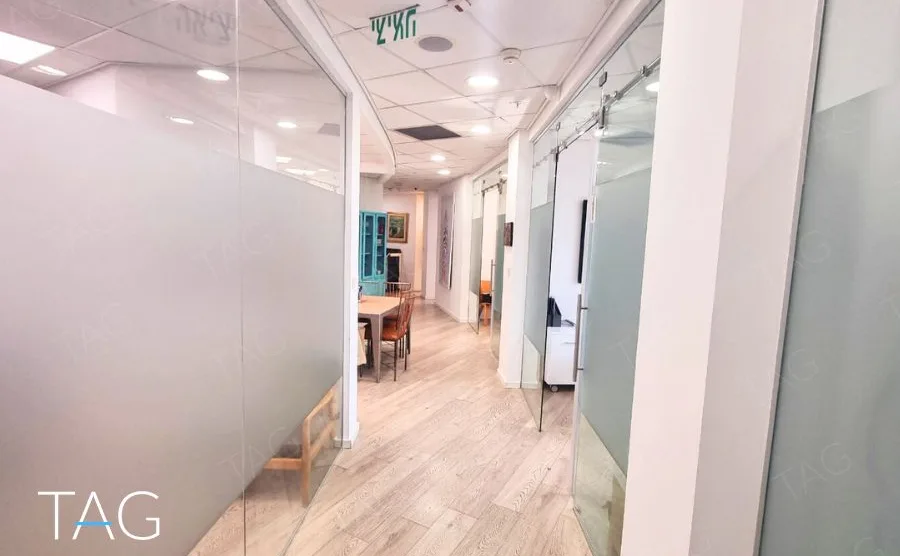מסדרון עם מחיצות זכוכית חלבית ודלתות הזזה במשרד במגדל רוטשילד 3