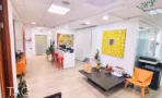 אזור קבלה פתוח עם רצפת עץ, מחיצות זכוכית ועבודות אמנות צבעוניות במשרד 350 מ
