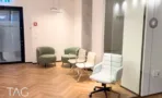 פינת המתנה בACRO BUSINESS CAMPUS עם כורסאות ירוקות, פרקט אדרה ותאורה תלויה - תג נכסים