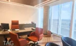 חדר מנהלים בACRO BUSINESS CAMPUS עם שולחן ישיבות, כורסאות כתומות ונוף מהחלון - תג נכסים