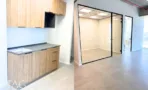 מטבחון בACRO BUSINESS CAMPUS עם ארונות עץ, משטח כהה ומחיצת זכוכית שחורה - תג נכסים