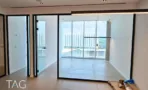 חלל פתוח בACRO BUSINESS CAMPUS עם דלתות זכוכית שחורות ונוף עירוני מהחלון - תג נכסים