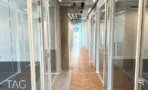 מסדרון משרדים בACRO BUSINESS CAMPUS עם מחיצות זכוכית ופרקט אדרה בהיר - תג נכסים