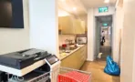 מטבחון ומסדרון במשרד במגדלי אלון עם ארונות בהירים ומכונת צילום