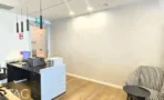 חדר עבודה במשרד במגדלי אלון עם שולחן כהה ושידת אחסון לבנה