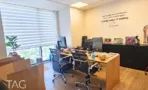 חדר מנהל במשרד להשכרה במגדלי אלון עם שולחן עץ, כתובת קיר וחלון גדול