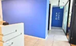 אזור קבלה במשרד במגדלי אלון עם קיר כחול ואייקונים ומחיצות זכוכית