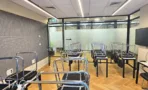משרד להשכרה 180 מ״ר במגדל אלון תל אביב, חדר הדרכה עם שולחנות וכיסאות מול קיר אקוסטי