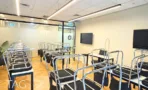משרד להשכרה 180 מ״ר במגדל אלון תל אביב, חלל הדרכה רחב עם שורות שולחנות ומסכים על הקיר
