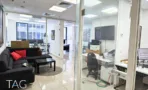 משרד להשכרה 180 מ״ר במגדלי אלון, פינת ישיבה עם ספה מול חדרי עבודה מזוגגים