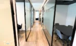 מסדרון בין חדרי זכוכית משני הצדדים ברצפת פרקט