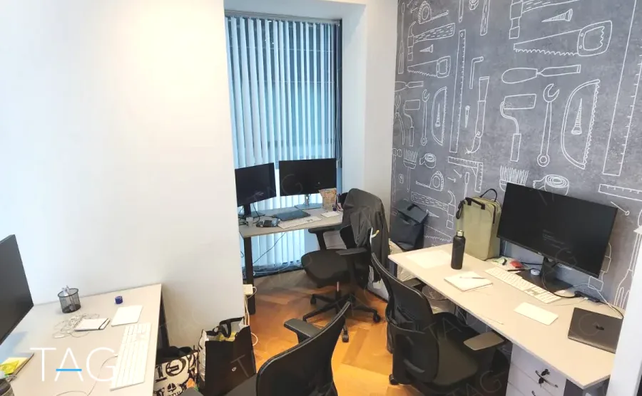 אזור עבודה עם עמדות מחשב וקיר איורים בסגנון לוח גיר