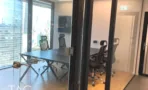 חדר ישיבות עם שולחן כהה וקיר זכוכית אל נוף העיר