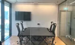 חדר ישיבות עם שולחן כהה ומסך על הקיר