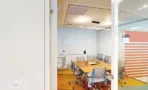 משרד להשכרה 520 מ״ר במגדלי עזריאלי, חדר ישיבות עם שולחן עץ, כיסאות אפורים ולוח מחיק