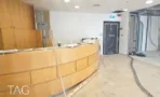 משרד להשכרה 165 מ״ר במגדלי עזריאלי, דלפק קבלה מעץ באזור כניסה בשיפוץ