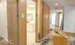 משרד להשכרה 165 מ״ר במגדלי עזריאלי, מסדרון עם דלתות עץ ומטבחון בשלבי שיפוץ