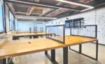 עמדות עבודה בשולחנות עץ עם מחיצות רשת באופן ספייס של משרד להשכרה באזור רוטשילד תל אביב