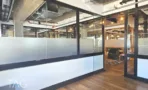 מחיצות זכוכית חלבית ותקרה חשופה עם תעלות מיזוג במשרד להשכרה באזור רוטשילד תל אביב