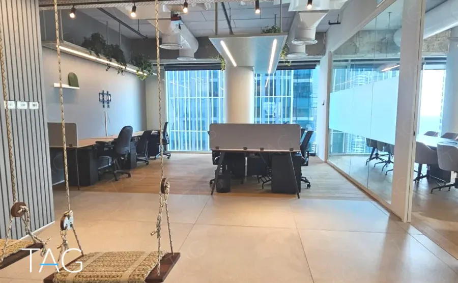 אופן ספייס עם נדנדה וצמחייה מול חלונות פנורמיים במשרד 1173 מ״ר במגדל אקרו