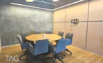 חדר ישיבות עם שולחן עגול וכיסאות כחולים במשרד 1173 מ״ר במגדל אקרו