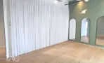 חלל עם וילונות לבנים וקיר מחורץ ירוק עם פתחי קשת במשרד 1173 מ״ר במגדל אקרו