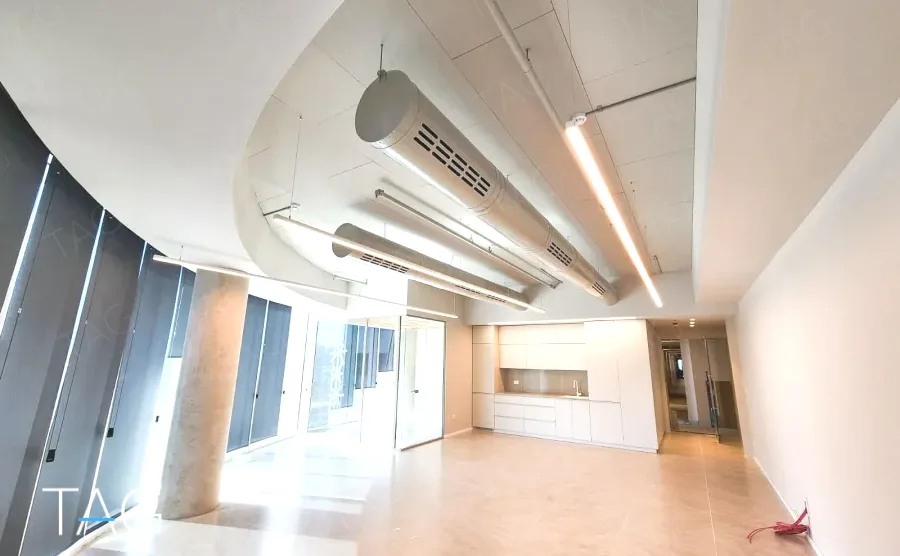 חלל משרדי בACRO BUSINESS CAMPUS עם תעלות מיזוג גלויות ותאורה ליניארית - תג נכסים