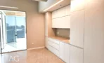 מטבחון בACRO BUSINESS CAMPUS עם ארונות לבנים גבוהים ויציאה למרפסת - תג נכסים