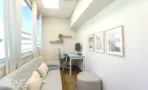 חדר עבודה עם ספה בהירה ועמדת מחשב ליד החלון במשרד להשכרה באזור רוטשילד