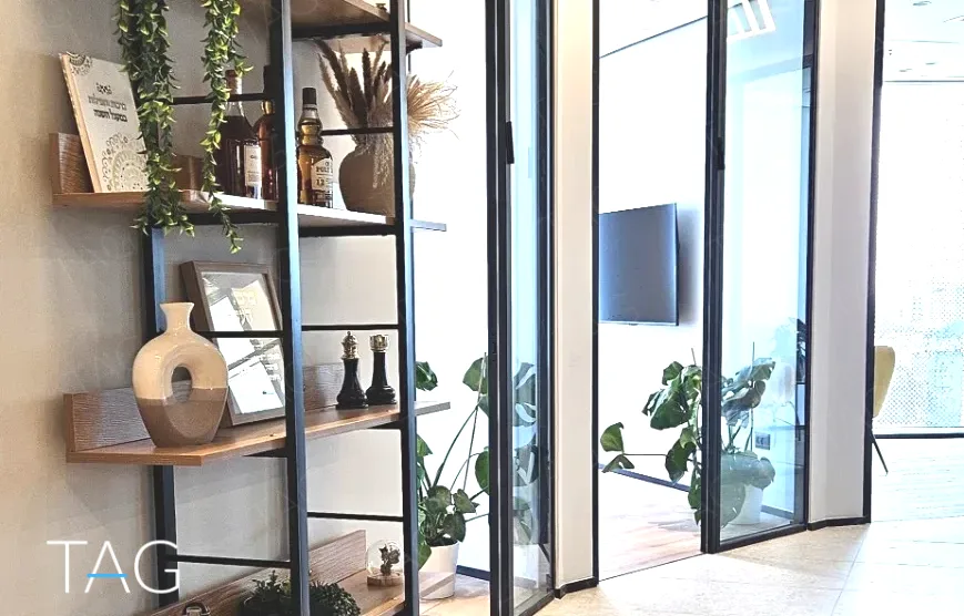 פינת ישיבה בACRO BUSINESS CAMPUS עם כוורת מדפים, צמחייה ומחיצות זכוכית - תג נכסים