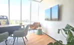 פינת פגישות בACRO BUSINESS CAMPUS עם שולחן, כורסאות מרופדות ונוף מהחלון - תג נכסים