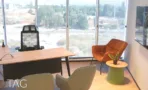 חדר מנהל בACRO BUSINESS CAMPUS עם שולחן עץ, כורסה כתומה ונוף לשטח פתוח - תג נכסים