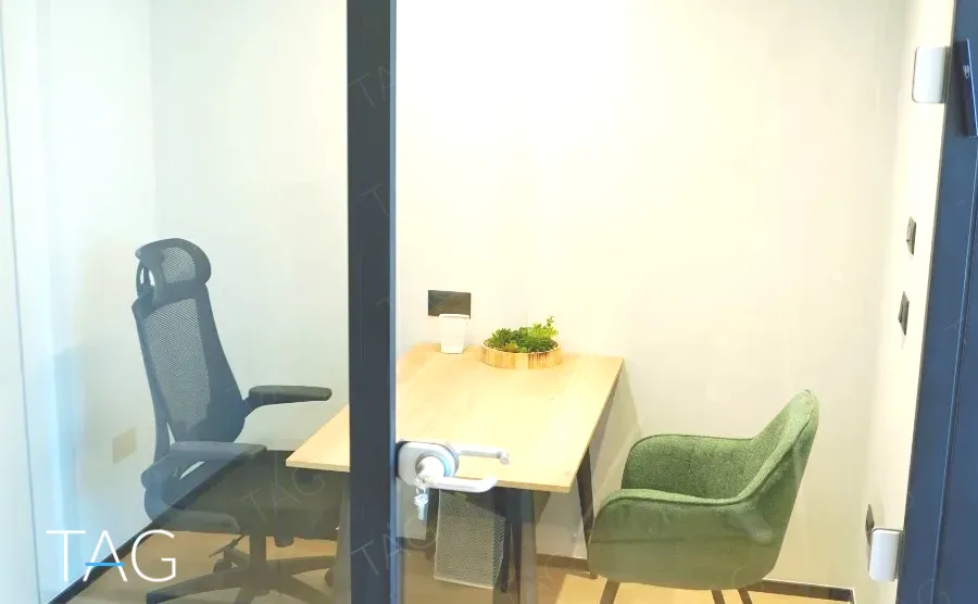 חדר שיחות קטן בACRO BUSINESS CAMPUS עם שולחן, כיסא ארגונומי וכורסה ירוקה - תג נכסים