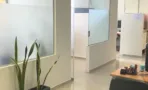מסדרון משרד עם מחיצת זכוכית חלבית וריצוף בהיר, במשרד להשכרה 173 מ