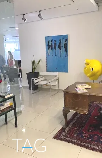 פינת קבלה עם שולחן עץ עתיק ושטיח פרסי, במשרד להשכרה 173 מ